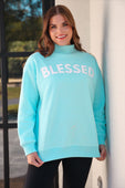 A soft mint green blessed mock neck pullover sweatshirt with bold white lettering fits size comfortably