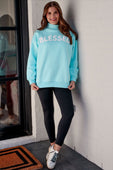 A light blue oversized blessed mock neck pullover sweatshirt with white lettering fits size comfortably