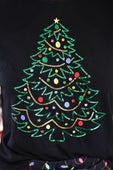 Black t-shirt with an embellished christmas tree design featuring green gold red blue and yellow sequins christmas tree tee