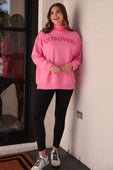 A vibrant pink extrovert mock neck pullover with bold red extrovert print in an oversized fits size style
