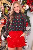 Red sequined mini skirt with drawstring waist paired with keigan mesh top featuring christmas polka dots design