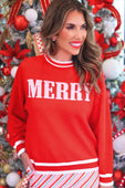 Red merry jacquard knit sweater featuring white lettering and striped cuffs in a festive jacquard knit design